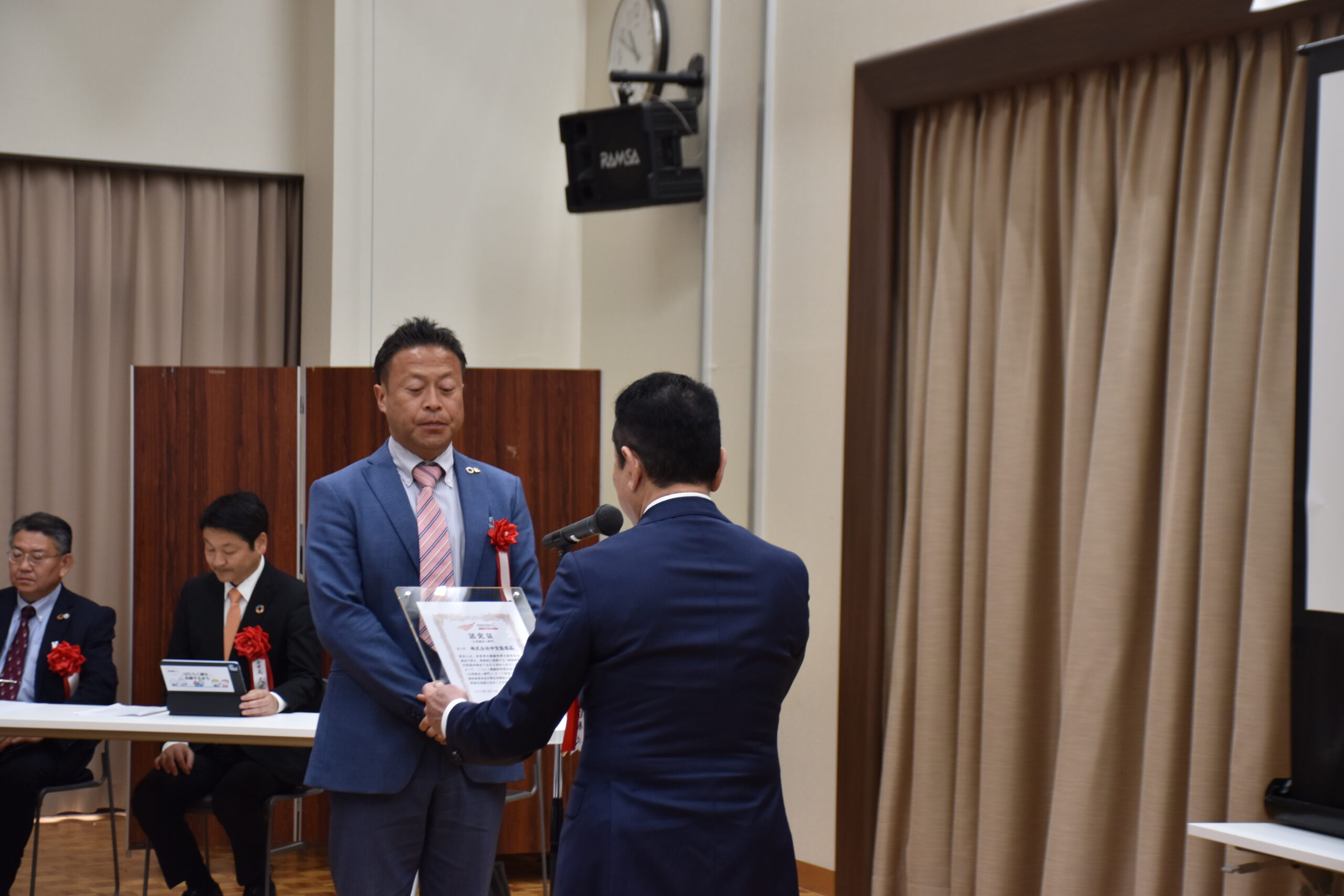 健康経営優良法人認定証の盾の授与の様子(当社の人事・総務部長の石川)